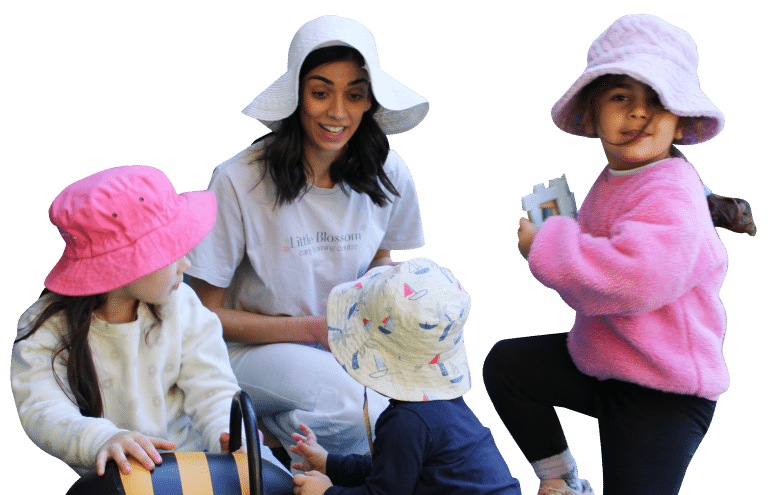 An educator sitting with children in sun hats