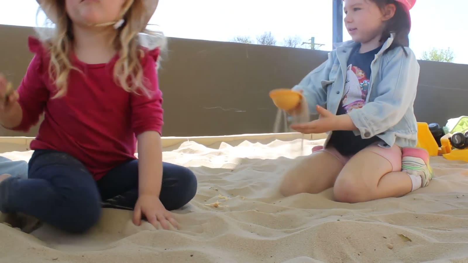 Two girls playing in the sandpit