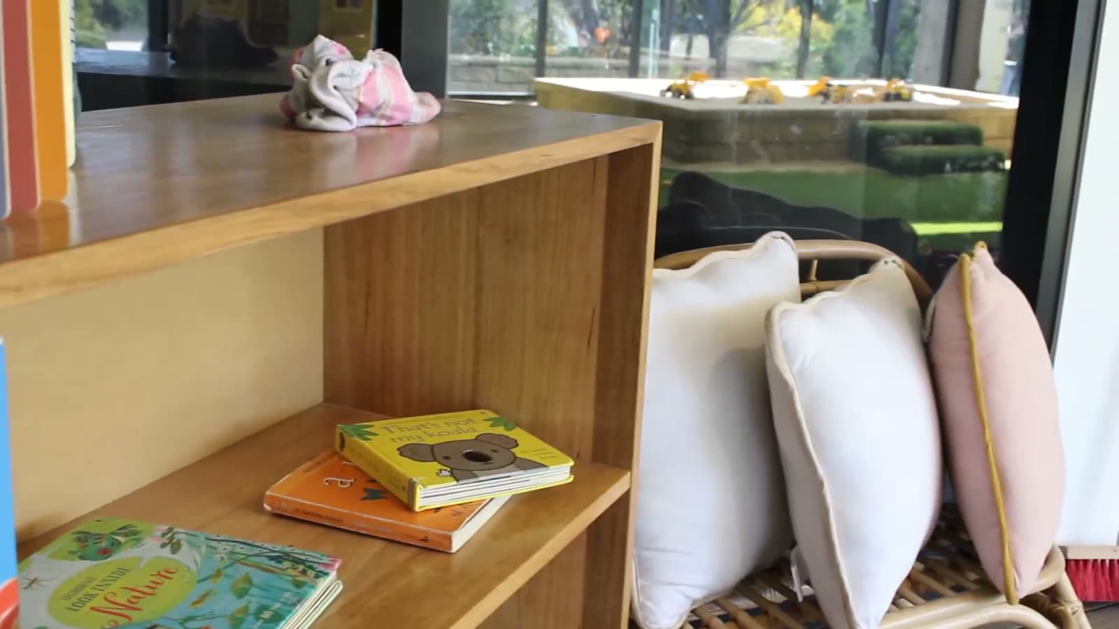 A cosy reading shelf with books and cushions